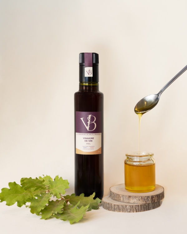 Bouteille de vinaigre de vin au miel avec pot de miel et feuille de chêne sur fond clair