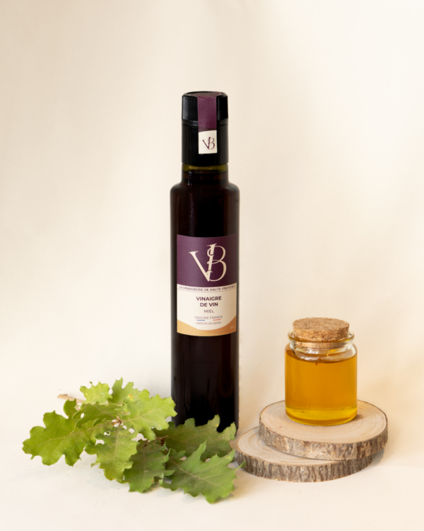 Bouteille de vinaigre de vin au miel avec pot de miel et feuille de chêne sur fond clair