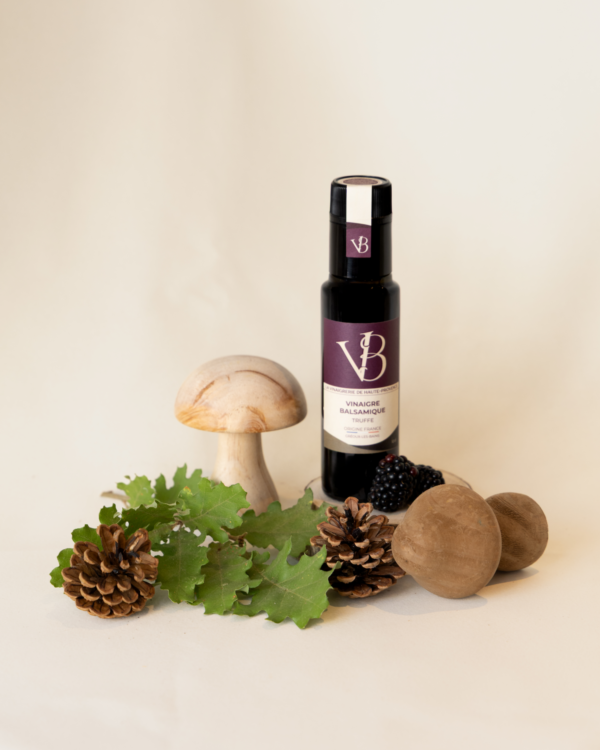 truffe 2 Bouteille de vinaigre balsamique à la truffe entourée de feuilles de chêne, pommes de pin et champignons décoratifs