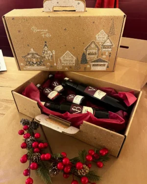 coffret noel 1 Coffret de Noël artisanal contenant des bouteilles de vinaigre et balsamique, emballé dans une boîte décorative avec des illustrations hivernales.